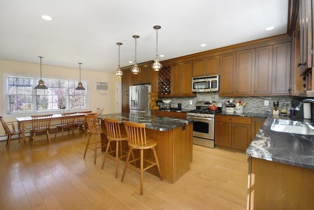 kitchen with a sink, appliances with stainless steel finishes, tasteful backsplash, and a breakfast bar