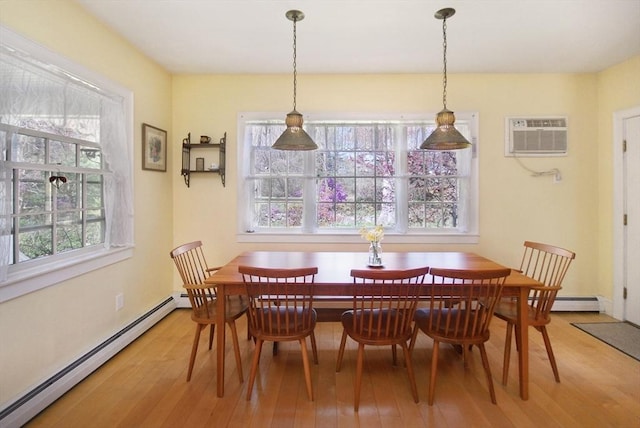 dining space with light wood finished floors and a baseboard radiator