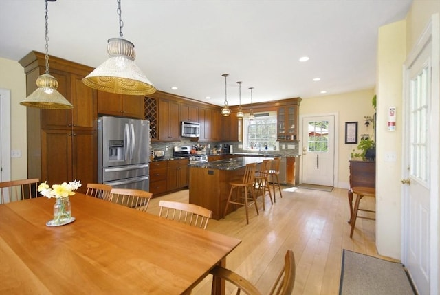 dining room with recessed lighting, light wood-style flooring, and baseboards