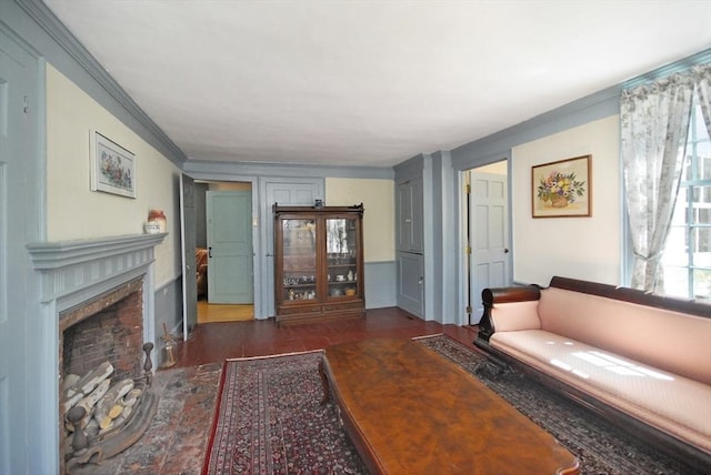 living area with a fireplace with flush hearth, ornamental molding, and wood finished floors