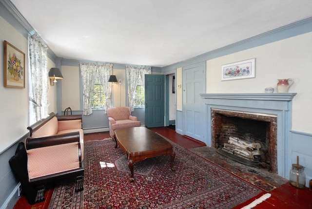 living room featuring a baseboard heating unit, ornamental molding, wood finished floors, and a fireplace