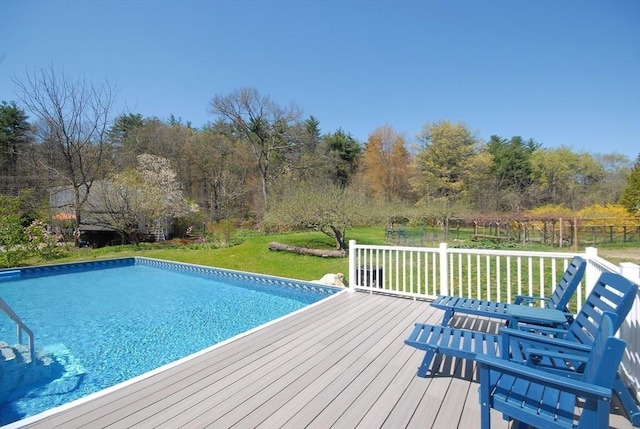 pool with a lawn and a wooden deck