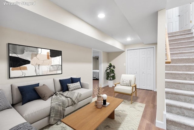 living area with recessed lighting, stairway, baseboards, and wood finished floors