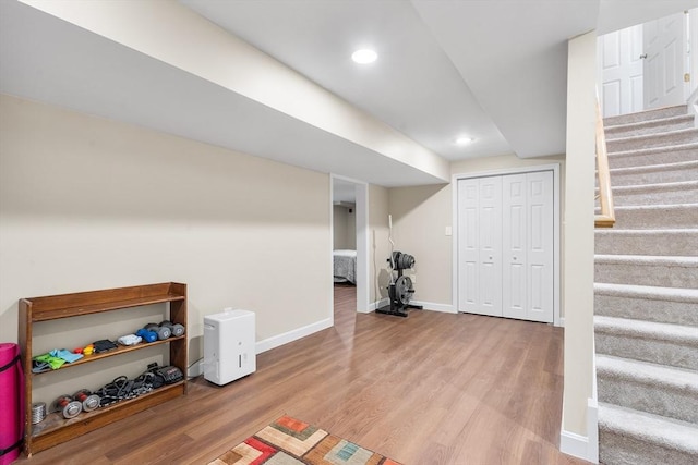 finished below grade area featuring baseboards, stairway, wood finished floors, and recessed lighting