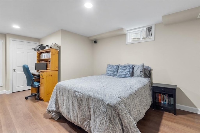 bedroom with baseboards, wood finished floors, and recessed lighting