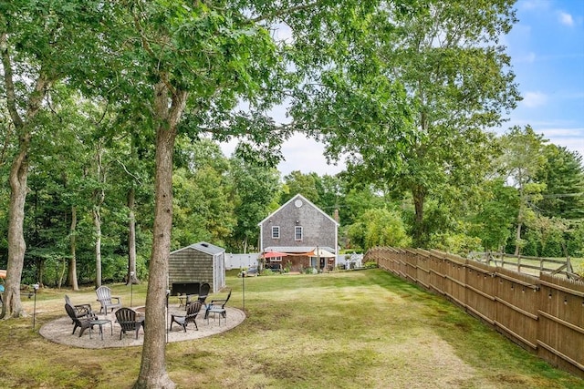 view of yard featuring an outdoor fire pit, an outdoor structure, and fence