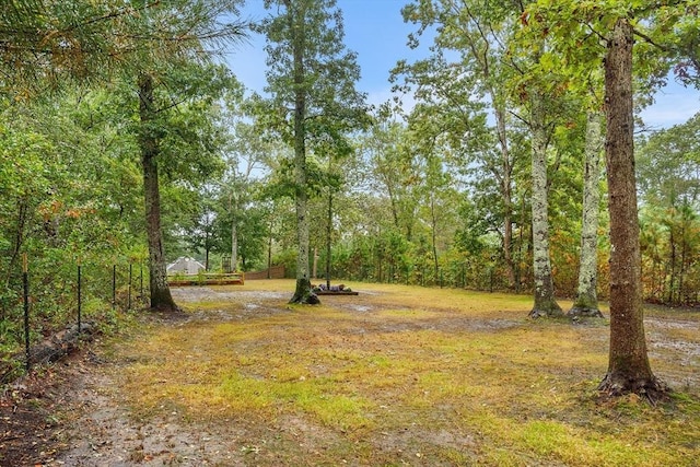 view of yard featuring a forest view and fence