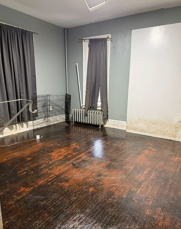 unfurnished room with hardwood / wood-style flooring and radiator