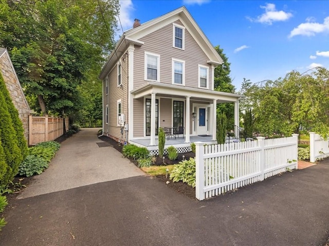 55 Dwight St, Dedham, MA 02026 - view of front of property with driveway, a porch, and a chimney