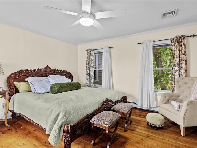 55 Dwight St, Dedham, MA 02026 - bedroom with a baseboard heating unit, wood finished floors, and ceiling fan