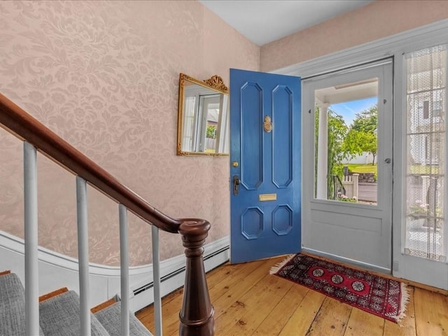 55 Dwight St, Dedham, MA 02026 - entrance foyer with wood-type flooring, wallpapered walls, stairway, and a baseboard radiator