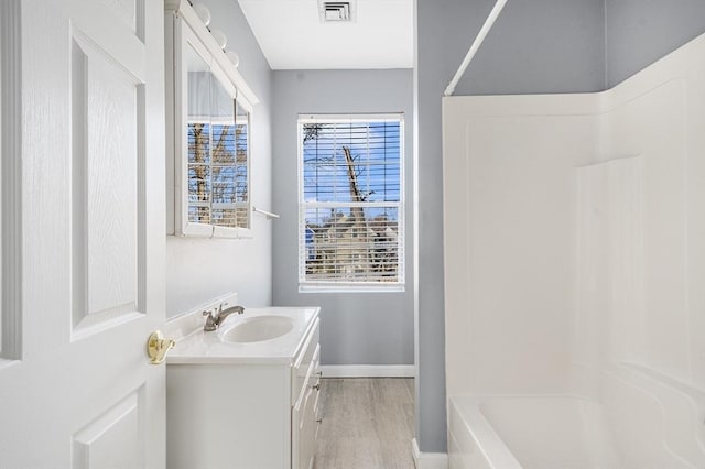 bathroom featuring hardwood / wood-style floors, vanity, and  shower combination