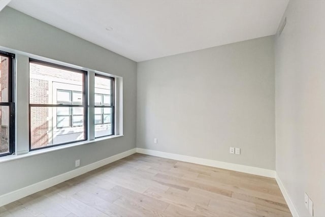 unfurnished room featuring light wood-type flooring and baseboards