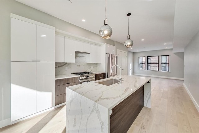 kitchen featuring stainless steel appliances, a sink, white cabinetry, decorative backsplash, and modern cabinets