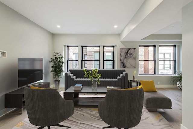 living area with recessed lighting, plenty of natural light, wood finished floors, and baseboards