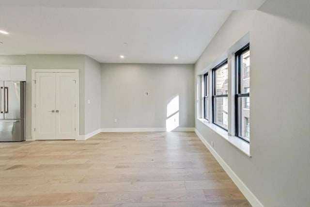 spare room with light wood-style floors, baseboards, and recessed lighting