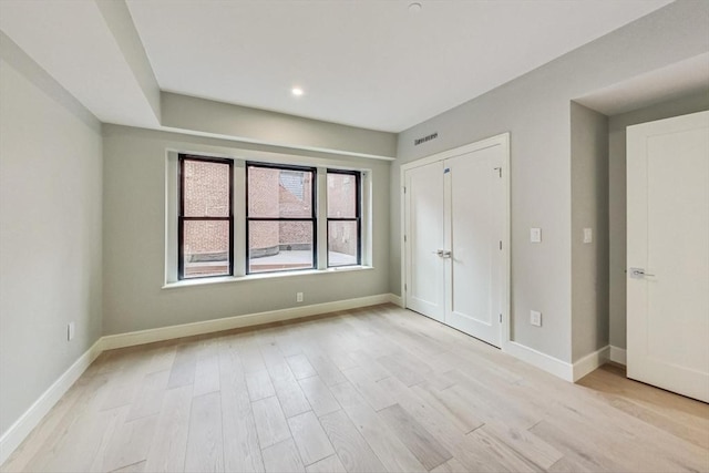 unfurnished bedroom featuring light wood-type flooring, visible vents, and baseboards