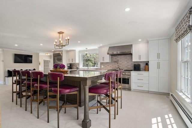 619 Main St, Hanover, MA 02339 - kitchen featuring baseboard heating, wall chimney exhaust hood, high end appliances, tasteful backsplash, and a center island