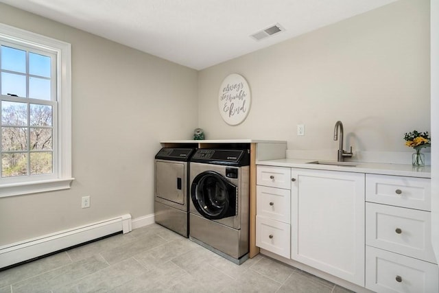 619 Main St, Hanover, MA 02339 - laundry room with washer and dryer, baseboard heating, cabinet space, baseboards, and light tile patterned floors