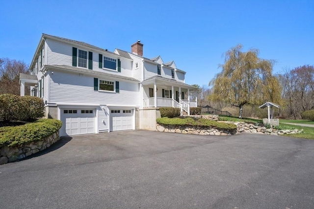 619 Main St, Hanover, MA 02339 - view of front facade featuring driveway, a chimney, a garage, and covered porch