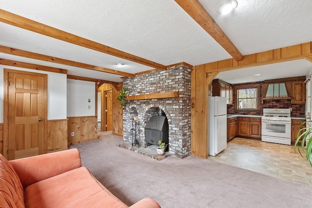 unfurnished living room with light colored carpet, wainscoting, beam ceiling, a textured ceiling, and wood walls