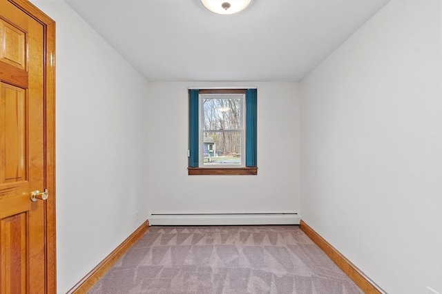 carpeted spare room featuring baseboards and a baseboard heating unit