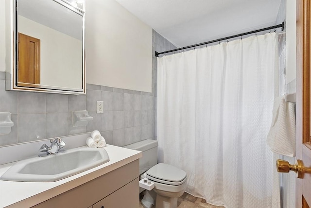 bathroom with toilet, tile walls, curtained shower, and vanity