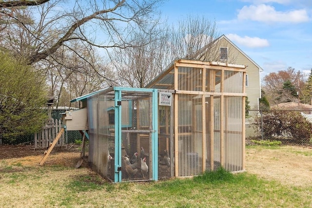 view of greenhouse with fence and a lawn
