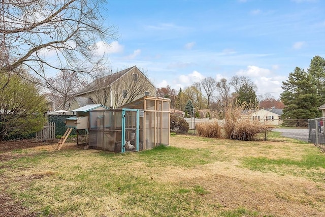 view of yard with an outdoor structure, a greenhouse, and a fenced backyard