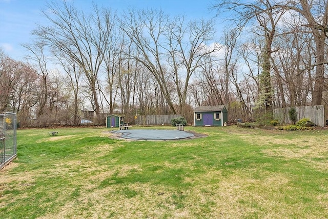 view of yard with a storage unit, a fenced backyard, and an outbuilding