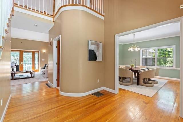 26 Sam Cobb Ln, Princeton, MA 01541 - entryway featuring light wood finished floors, a towering ceiling, a chandelier, and ornamental molding