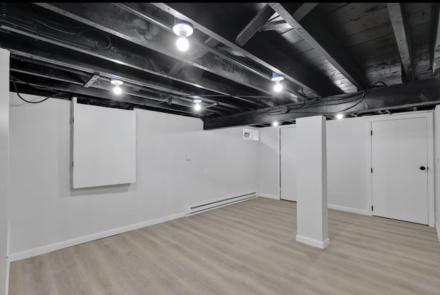 69 Notre Dame St, Springfield, MA 01104 - finished basement featuring a baseboard radiator, light wood-style flooring, and baseboards
