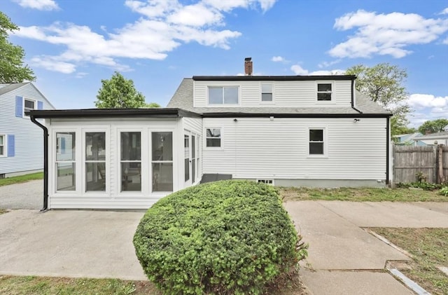 69 Notre Dame St, Springfield, MA 01104 - back of property with a chimney, a sunroom, a patio area, and a shingled roof