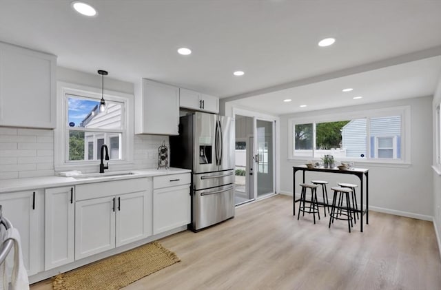 69 Notre Dame St, Springfield, MA 01104 - kitchen with stainless steel fridge with ice dispenser, a sink, light wood-style flooring, tasteful backsplash, and recessed lighting