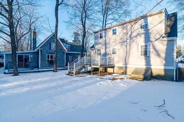 snow covered property featuring a wooden deck