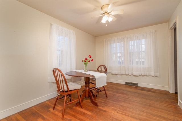 dining space featuring wood-type flooring and ceiling fan