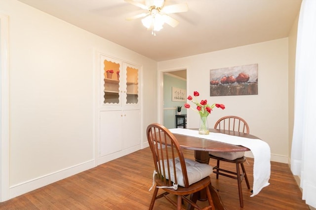 dining area with hardwood / wood-style floors and ceiling fan