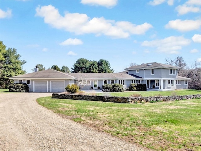 view of front of home with dirt driveway, an attached garage, a chimney, and a front lawn