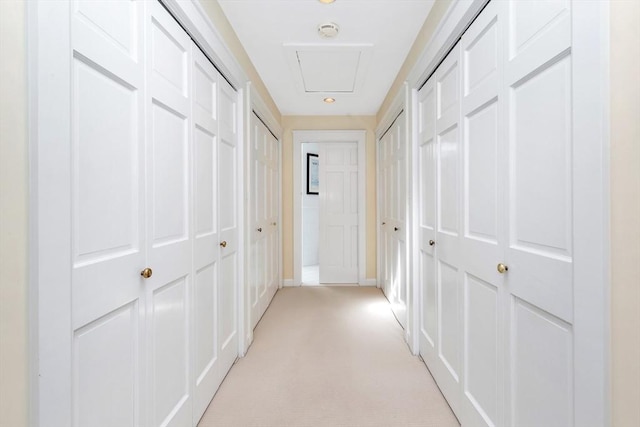 hallway featuring baseboards and light colored carpet