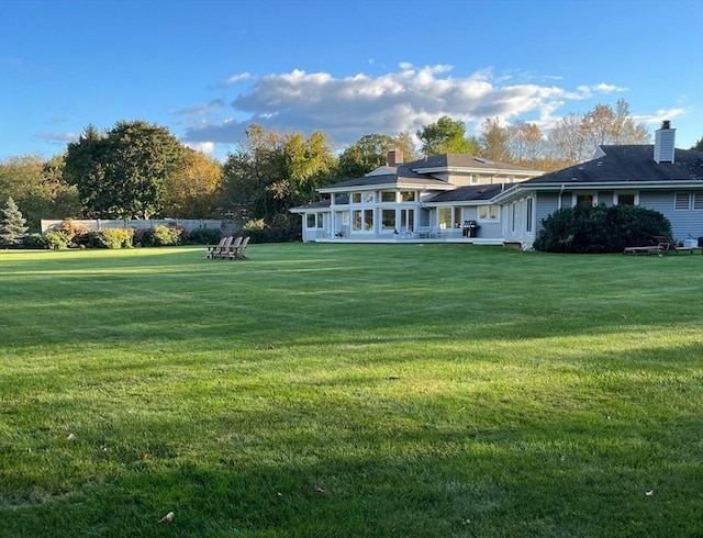 rear view of property with a lawn and a chimney