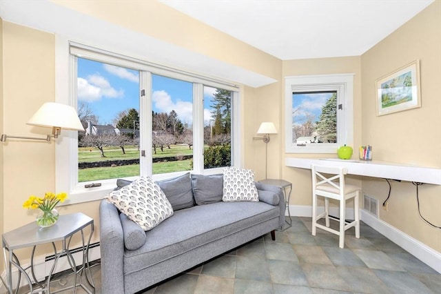 living area featuring baseboards, visible vents, and baseboard heating