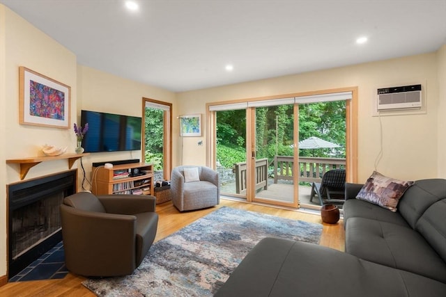 27 5th Ave Unit 27, Watertown, MA 02472 - living room with wood finished floors, a fireplace with flush hearth, a wall unit AC, and recessed lighting
