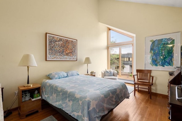 27 5th Ave Unit 27, Watertown, MA 02472 - bedroom with access to outside, wood finished floors, a towering ceiling, and baseboard heating