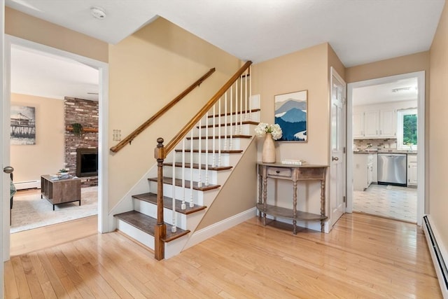 6 Magnolia Cir, Norfolk, MA 02056 - staircase with a baseboard heating unit, hardwood / wood-style flooring, and a fireplace