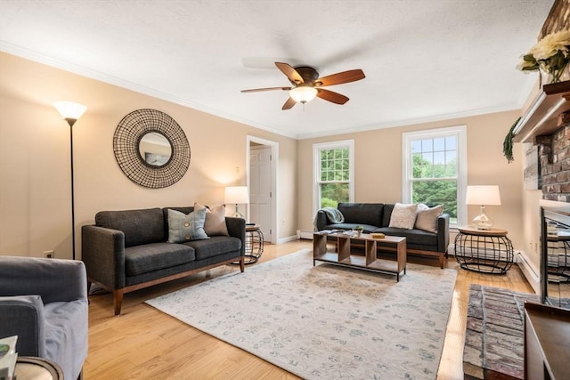 6 Magnolia Cir, Norfolk, MA 02056 - living area featuring a ceiling fan, ornamental molding, light wood-style flooring, a brick fireplace, and baseboard heating
