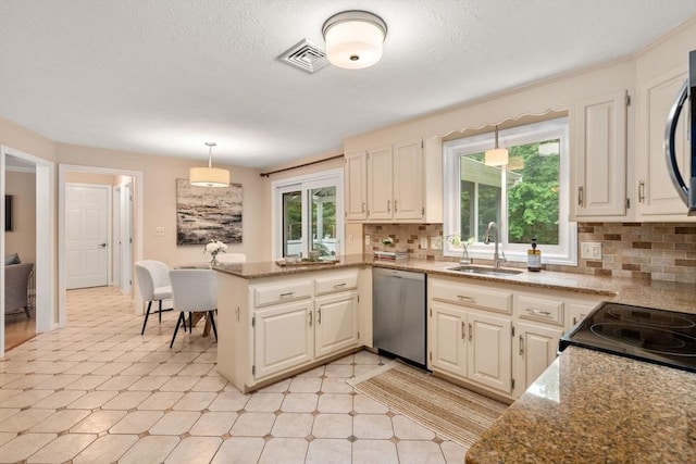 6 Magnolia Cir, Norfolk, MA 02056 - kitchen featuring dishwasher, a peninsula, healthy amount of natural light, backsplash, and a textured ceiling