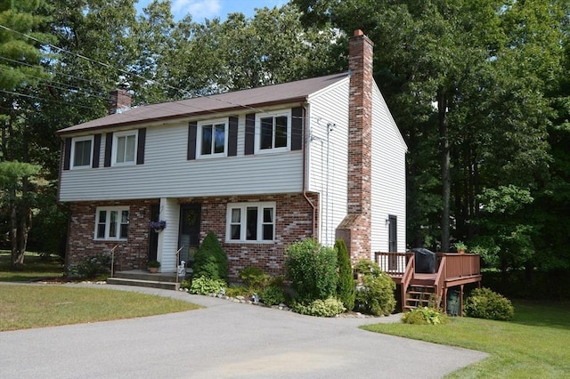 view of front facade featuring a deck and a front lawn