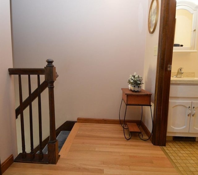 corridor featuring light wood-type flooring and sink