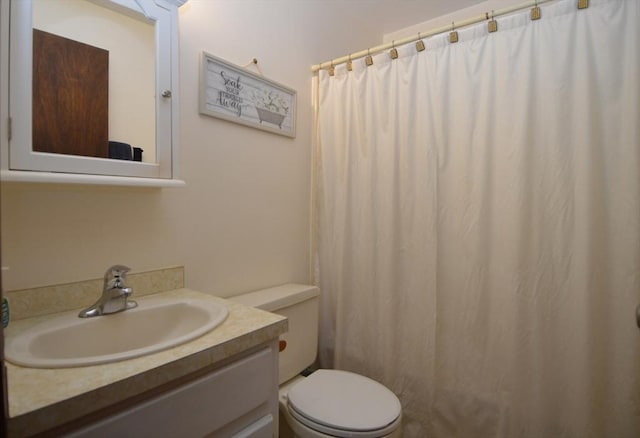 bathroom with vanity, a shower with shower curtain, and toilet