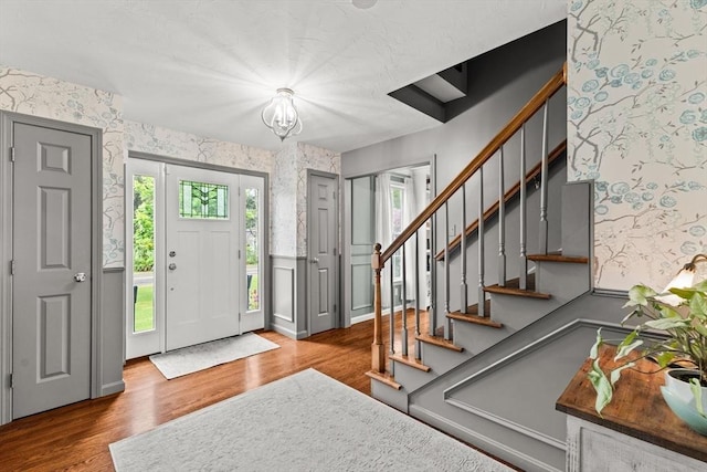 42 Britton St, Raynham, MA 02767 - entryway featuring wallpapered walls, plenty of natural light, wood finished floors, stairs, and a chandelier